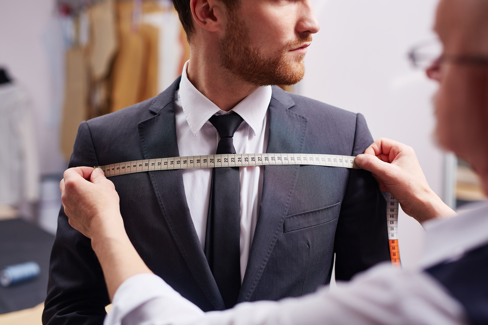 Mid,Section,Portrait,Of,Tailor,Fitting,Bespoke,Suit,To,Model